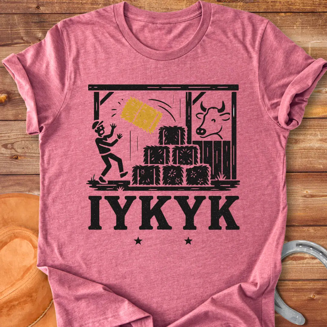 Funny t-shirt design featuring a person surprised by falling hay with a cow watching in the background.