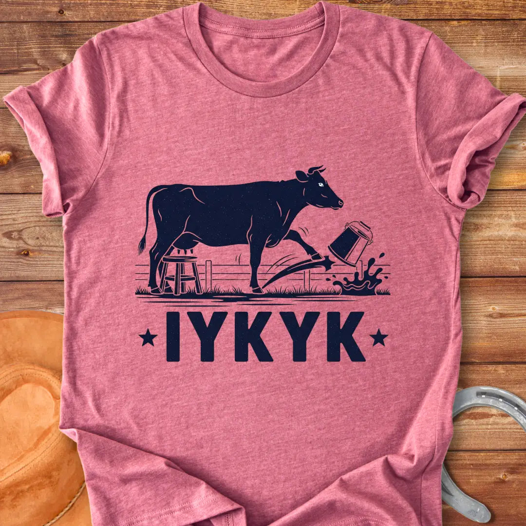Illustration of a cow kicking a bucket, with the words 'IYKYK' and a farm scene background.