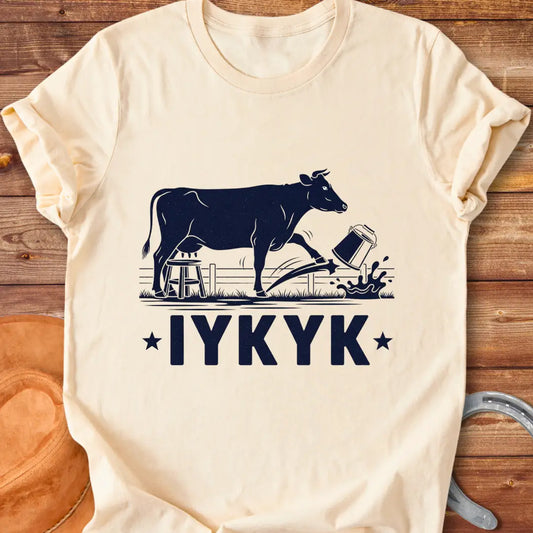 Illustration of a cow kicking a bucket, with the words 'IYKYK' and a farm scene background.