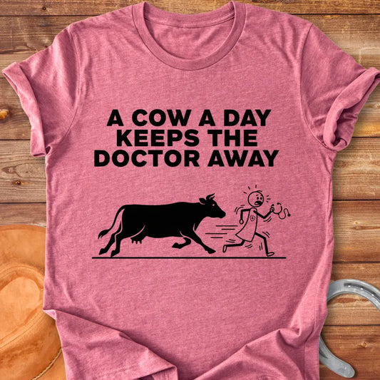 Black t-shirt design with a cow illustration and the text 'A Cow a Day Keeps the Doctor Away'