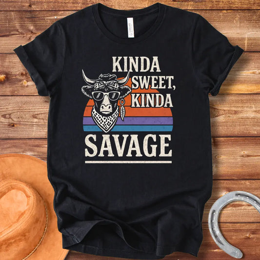 Vintage t-shirt featuring a cool cow wearing sunglasses and a bandana with the text 'Kinda Sweet Kinda Savage' over a retro sunset background.