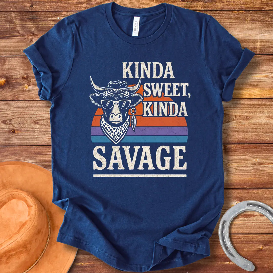 Vintage t-shirt featuring a cool cow wearing sunglasses and a bandana with the text 'Kinda Sweet Kinda Savage' over a retro sunset background.