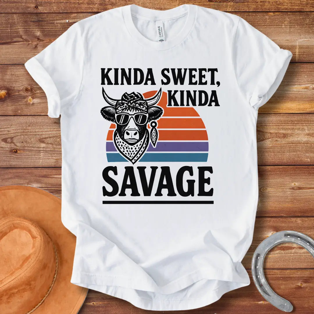 Vintage t-shirt featuring a cool cow wearing sunglasses and a bandana with the text 'Kinda Sweet Kinda Savage' over a retro sunset background.