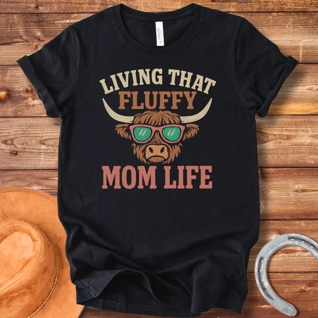 A graphic of a Highland cow wearing sunglasses with the text 'Living That Fluffy Mom Life' above and below it.