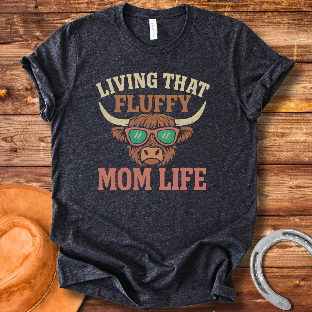 A graphic of a Highland cow wearing sunglasses with the text 'Living That Fluffy Mom Life' above and below it.