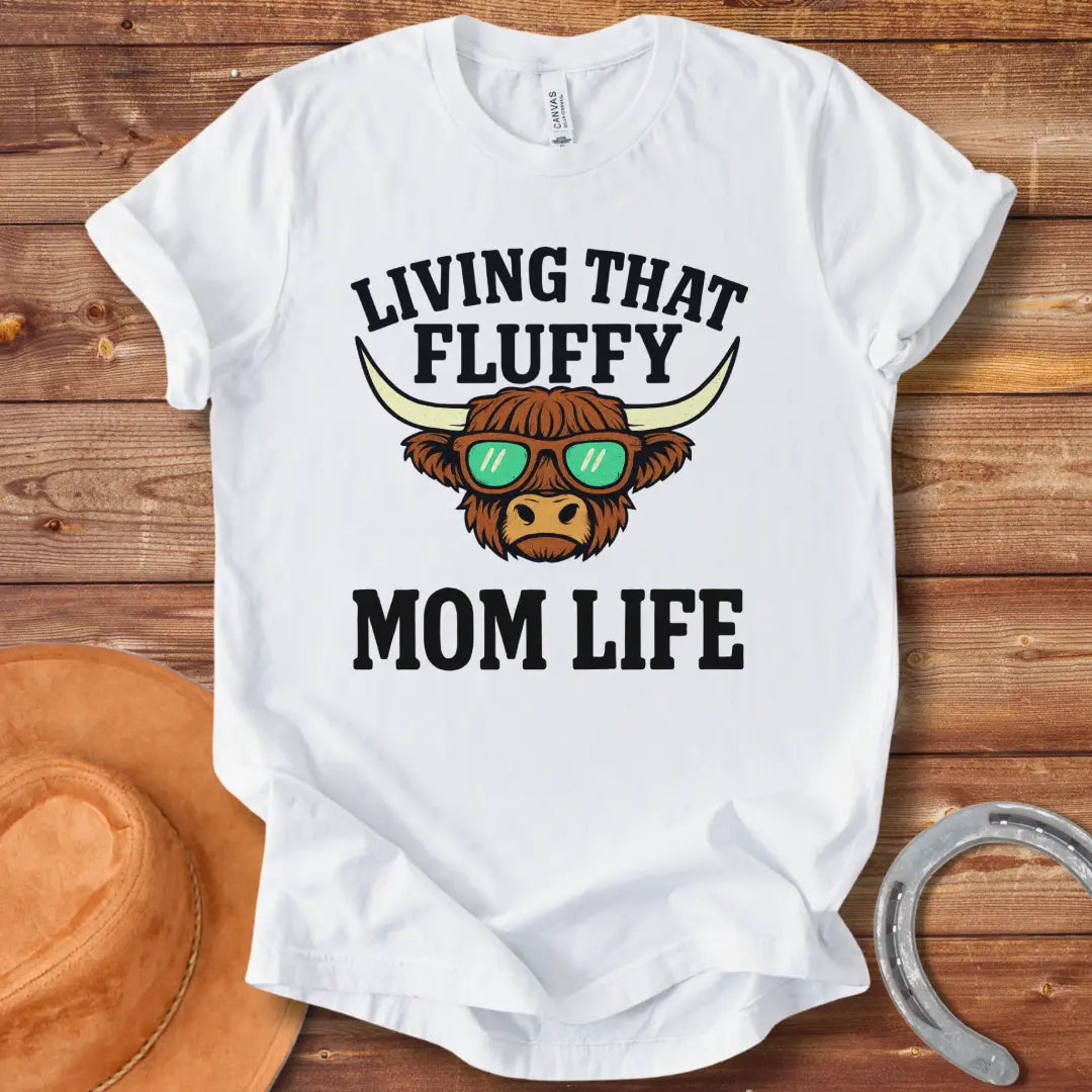 A graphic of a Highland cow wearing sunglasses with the text 'Living That Fluffy Mom Life' above and below it.