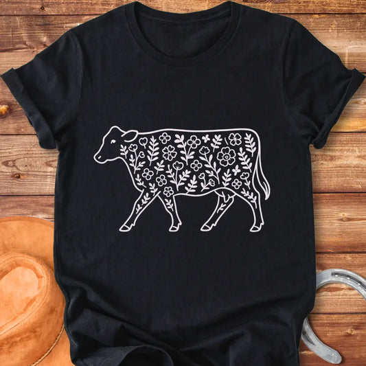 Black and white illustration of a cow with floral design inside.