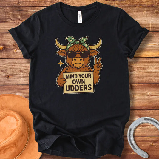 Illustration of a cool cow wearing sunglasses and a bandana, holding a sign that says 'Mind Your Own Udders' and giving a peace sign.
