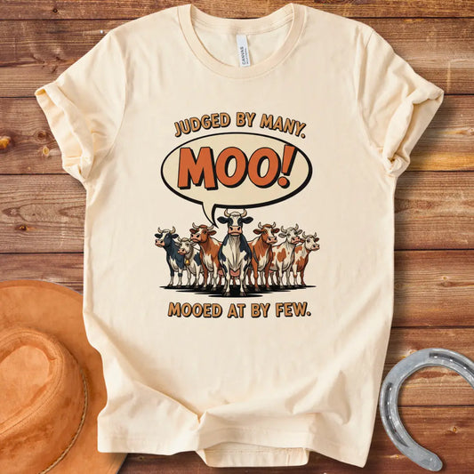 Moo-ed At By Few T-shirt featuring a group of cartoon cows with a speech bubble saying 'Moo!'