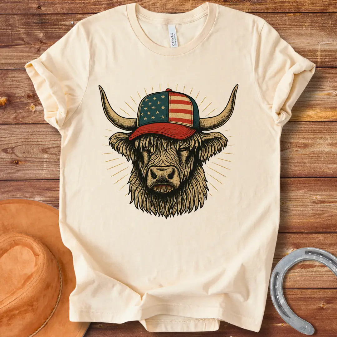 Illustration of a Highland cow wearing an American flag baseball cap, with sun rays emanating from behind the cow's head.