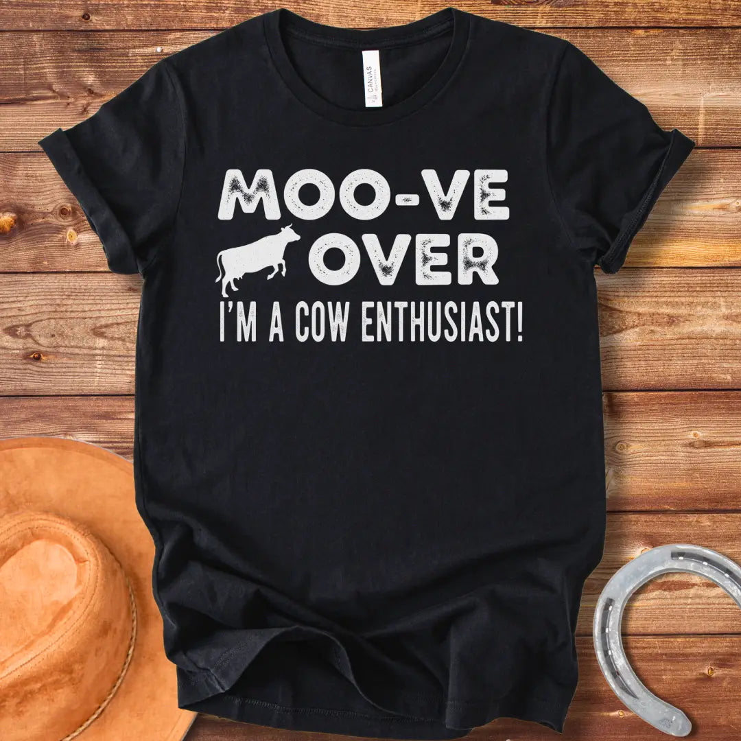 A black and white graphic tee design that says 'Moo-ve Over' with a silhouette of a cow and 'I'm a Cow Enthusiast!' below.