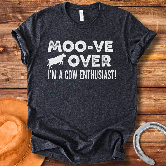A black and white graphic tee design that says 'Moo-ve Over' with a silhouette of a cow and 'I'm a Cow Enthusiast!' below.