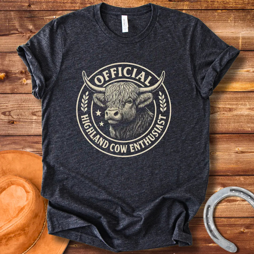 Official Highland Cow Enthusiast T-Shirt design featuring a detailed illustration of a Highland cow's head within a circular emblem with the words 'Official Highland Cow Enthusiast' written on it.