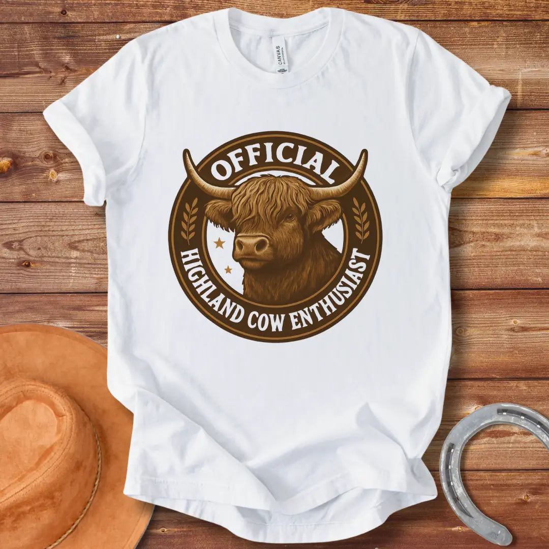 Official Highland Cow Enthusiast T-Shirt design featuring a detailed illustration of a Highland cow's head within a circular emblem with the words 'Official Highland Cow Enthusiast' written on it.