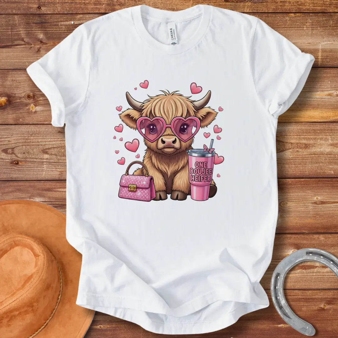 Illustration of a fluffy cow wearing heart-shaped sunglasses and holding a pink drink and purse that says 'One Boujee Heifer' with pink hearts surrounding it.