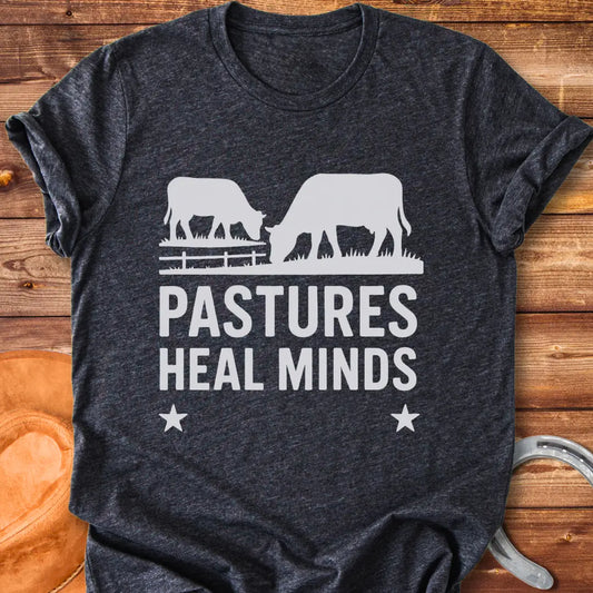 Two cows grazing in a pasture with the text 'Pastures Heal Minds' in a unique design.