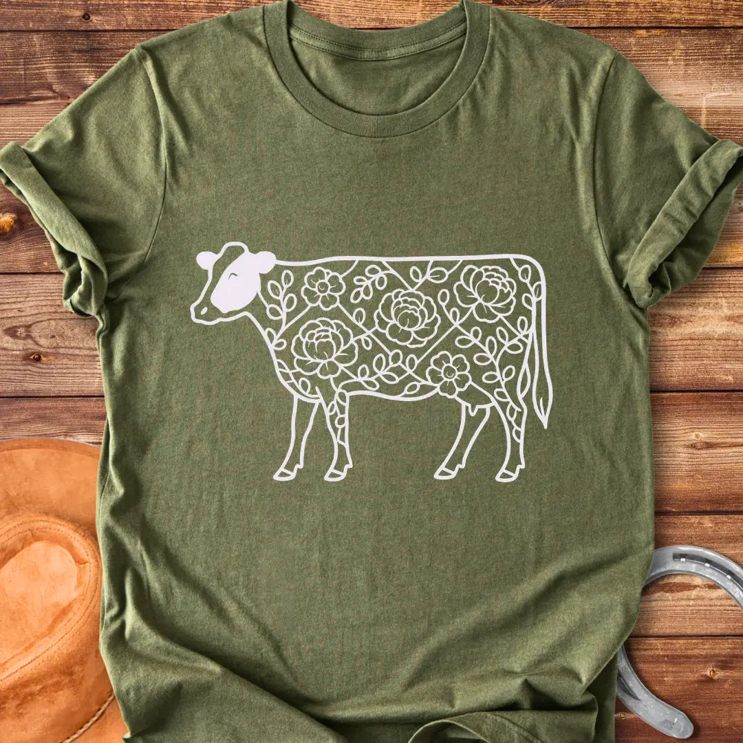 Silhouette of a holstein cow filled with peony flowers and eucalyptus leaves, in green outline.