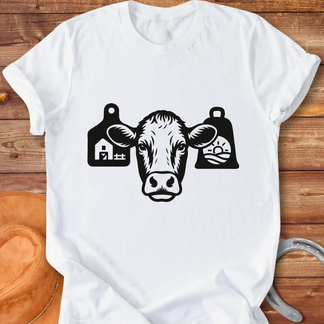Black and white silhouette of a cow's head with bell tags, one showing a farm and the other with a landscape with sun
