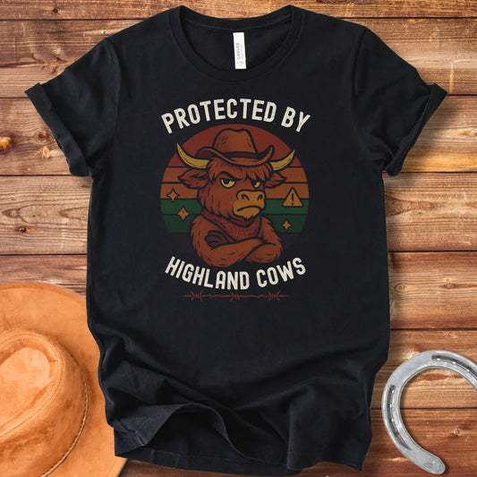Protected by Highland Cows t-shirt featuring a cartoon Highland cow wearing a cowboy hat with a stern look.