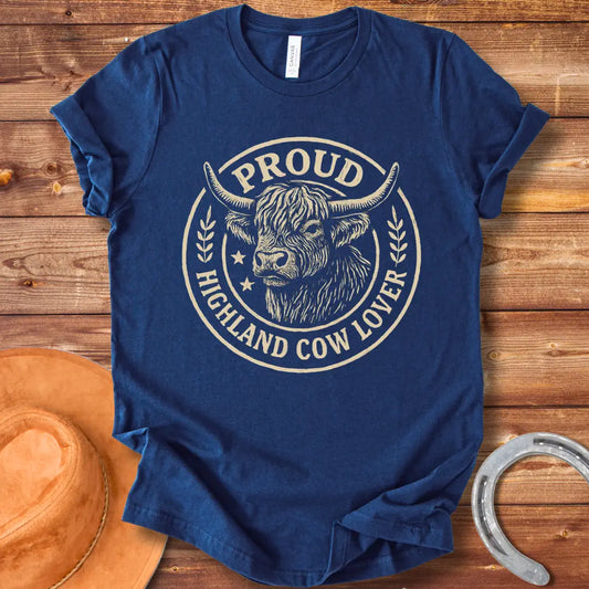 Proud Highland Cow Lover T-Shirt featuring a detailed illustration of a Highland cow's head and the text 'Proud Highland Cow Lover' in a circular design.