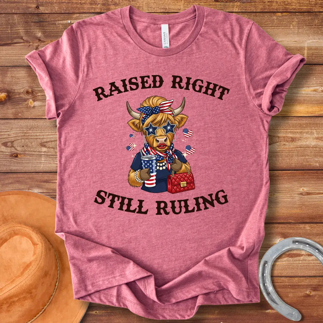 Stylish cow wearing star sunglasses and a patriotic scarf, holding a drink and purse, with the text 'Raised Right Still Ruling' above.