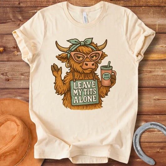 Illustration of a sassy cow wearing sunglasses, holding a Moo Juice drink and a sign that says 'Leave My Tits Alone'.