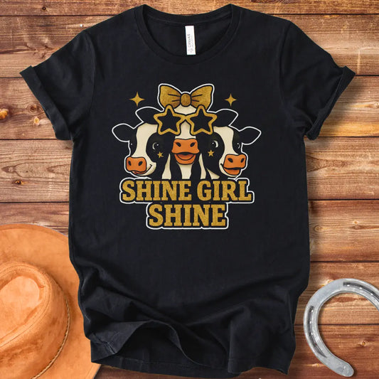 Shine Girl Shine t-shirt featuring three cute cow faces wearing star-shaped sunglasses and gold accents, perfect for cow lovers.