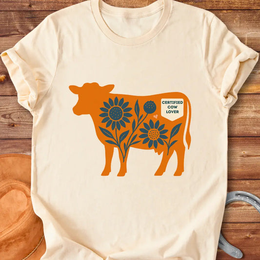 Sunflower Stockyard T-Shirt featuring an orange cow silhouette filled with blue sunflowers, a floral design, and a Certified Cow Lover badge.