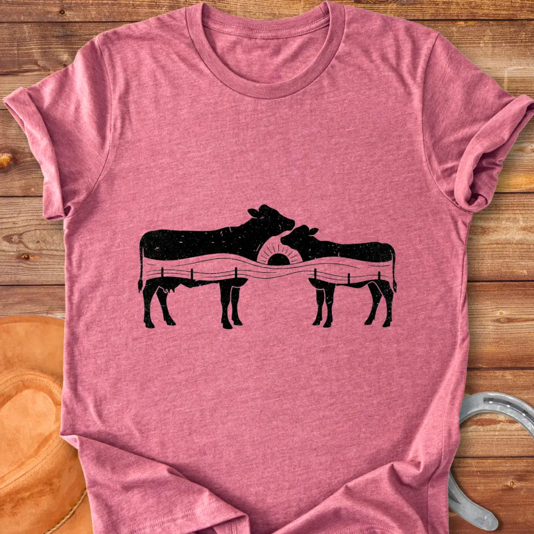 Silhouette design of a cow family with a sunset over a fence