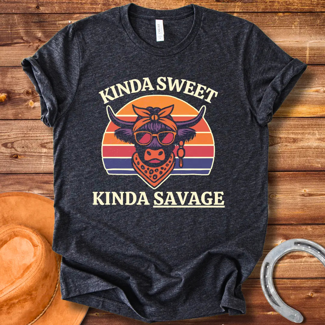 Retro t-shirt with a cool cow graphic, sunglasses, bandana, and the words 'Kinda Sweet, Kinda Savage' in a sunset background.