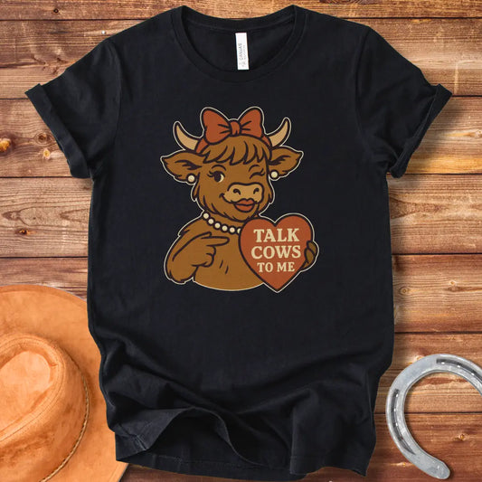 Charming cow wearing a bow and pearl necklace, holding a heart-shaped sign that says 'Talk Cows To Me'