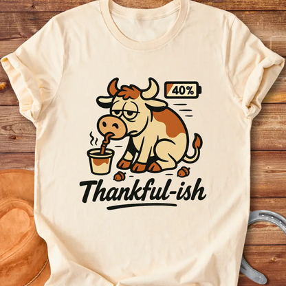 Tired cow drinking coffee, the words Thankful-ish underneath. A fun and relatable design for cow lovers.
