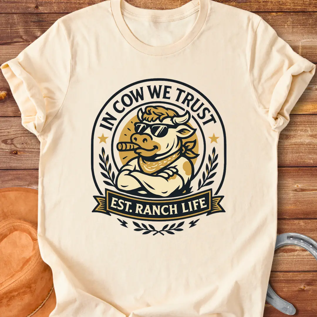 Trust Cow Badge T-Shirt featuring a cool cow wearing sunglasses and a bandana with the text 'In Cow We Trust' and 'Est. Ranch Life.'