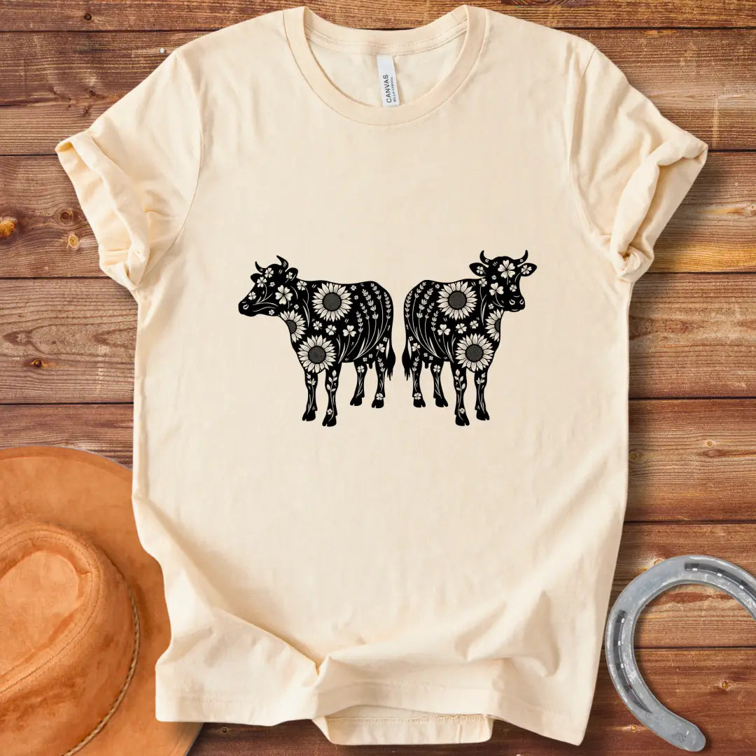 Twin floral cows t-shirt design featuring two cow silhouettes filled with sunflowers and floral patterns