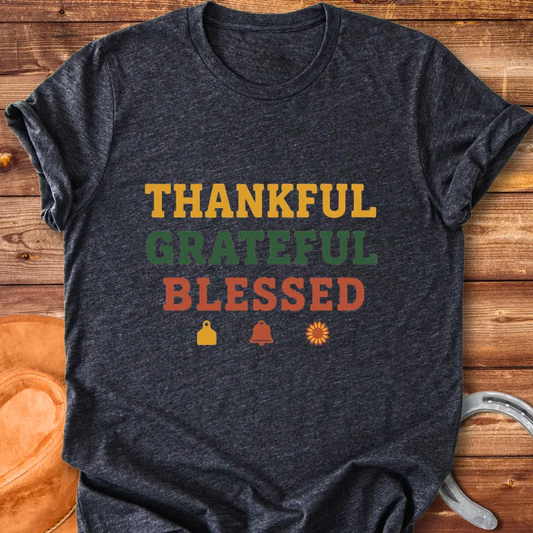 Thankful, Grateful, Blessed T-shirt with farm-themed elements like a cow tag, bell, and sunflower.