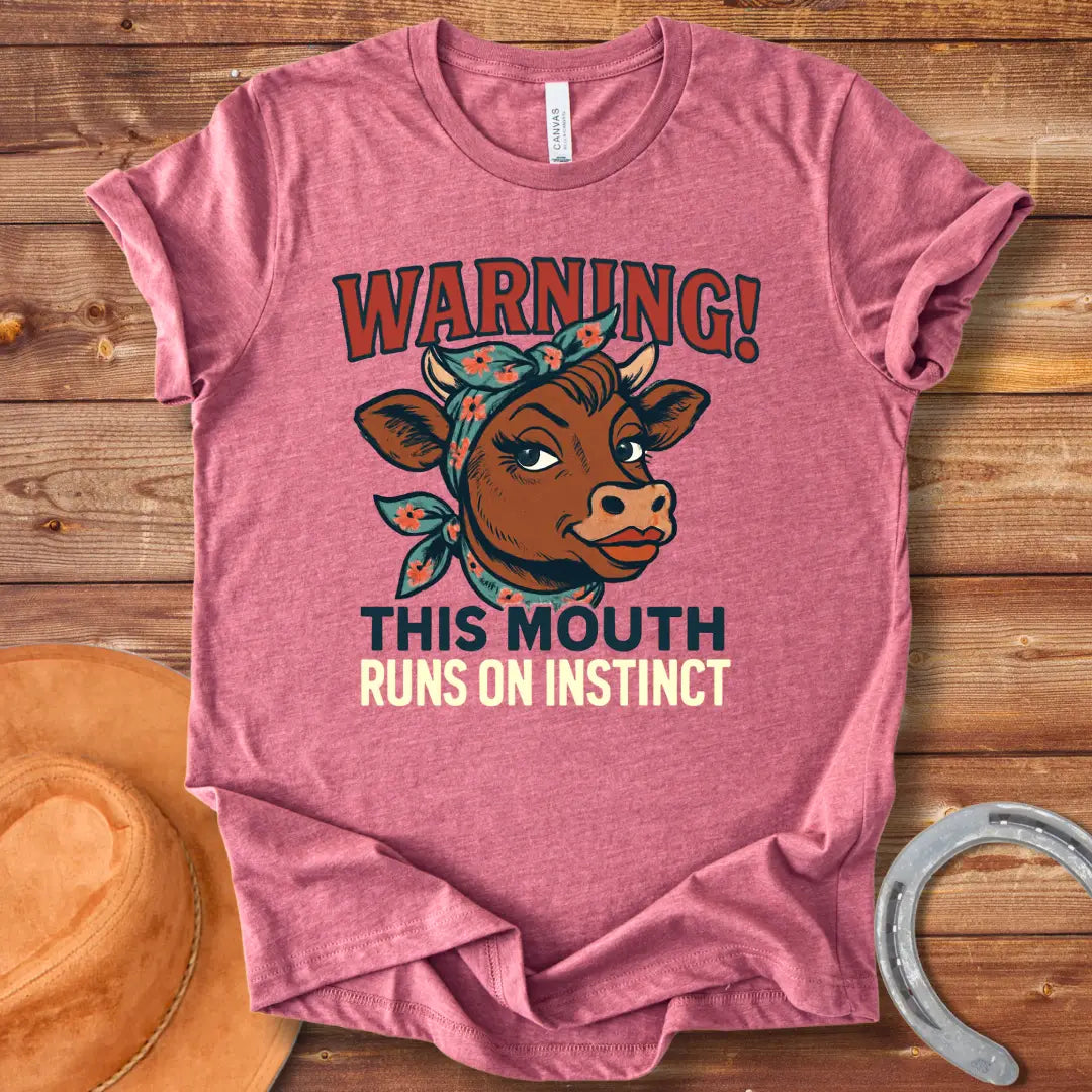 Illustration of a cow with a bandana and the words 'Warning! This Mouth Runs On Instinct' on a black background.
