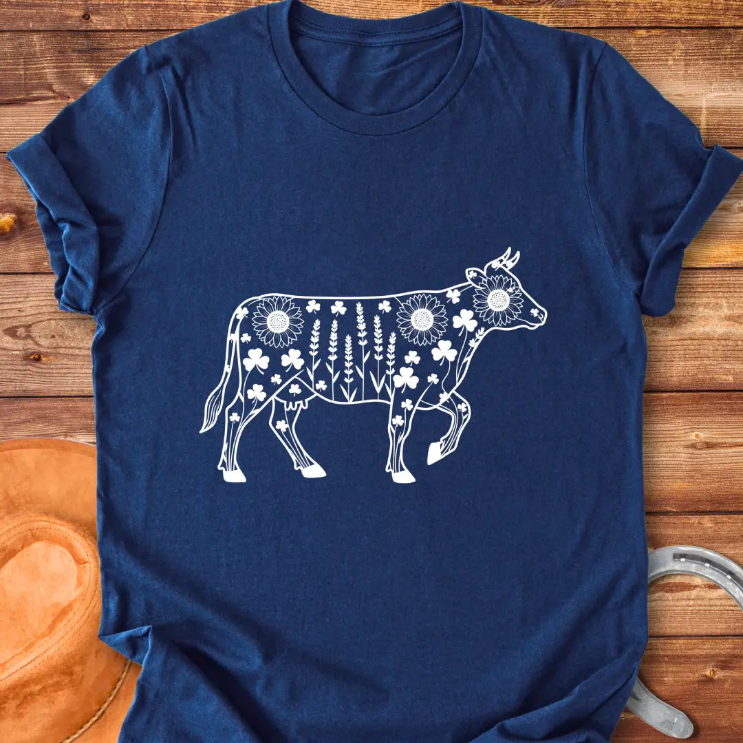 Line art of a cow filled with wildflowers, including sunflowers, lavender and clovers, on a black background.