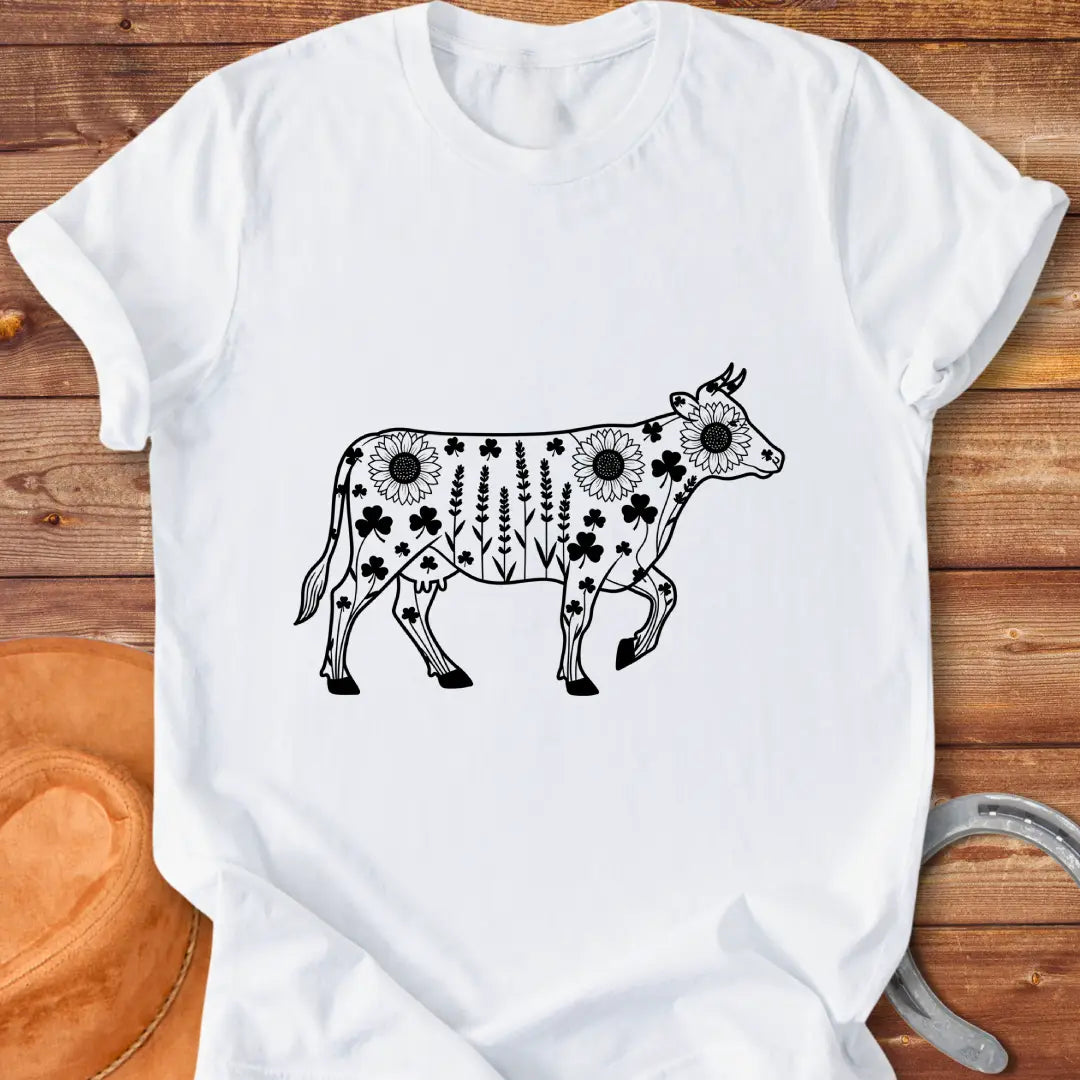 Line art of a cow filled with wildflowers, including sunflowers, lavender and clovers, on a black background.